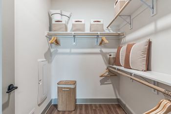 A bedroom with a bunk bed and a closet with shelves and a trash can